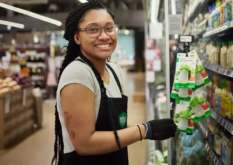 Team member stacking shelves in a Whole Foods store